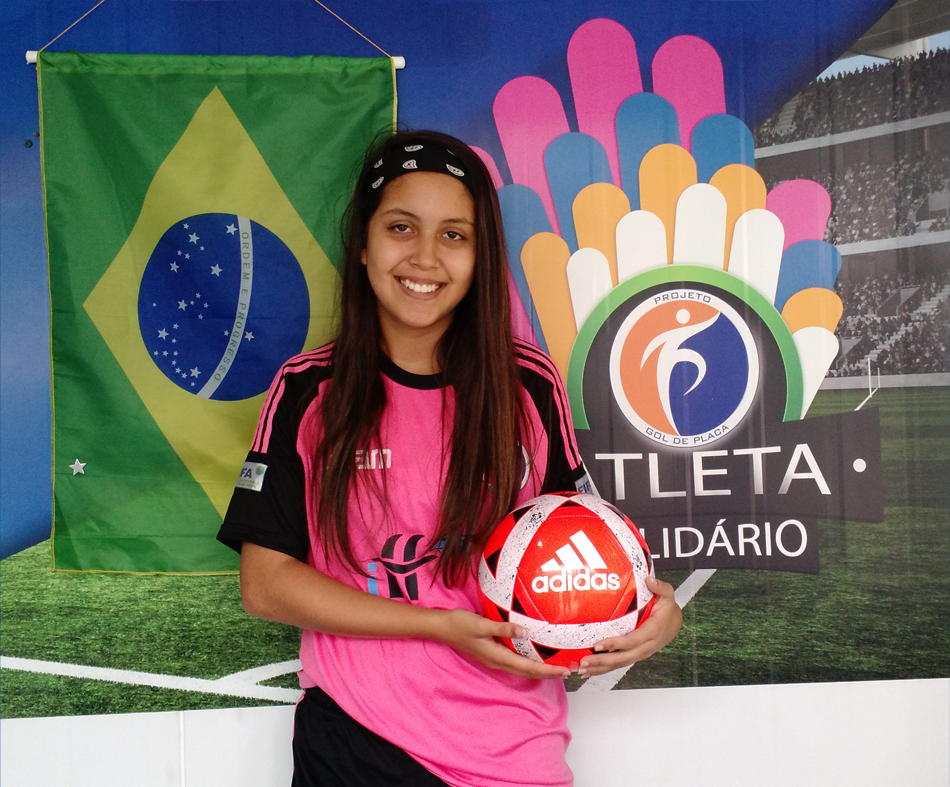 A atleta Yasmim Motta - Sub 15, doa bola para o Programa Atleta Solidário.