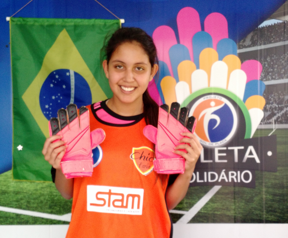 A atleta Yasmim Motta - Sub 15, doa luvas para o Programa Atleta Solidário.